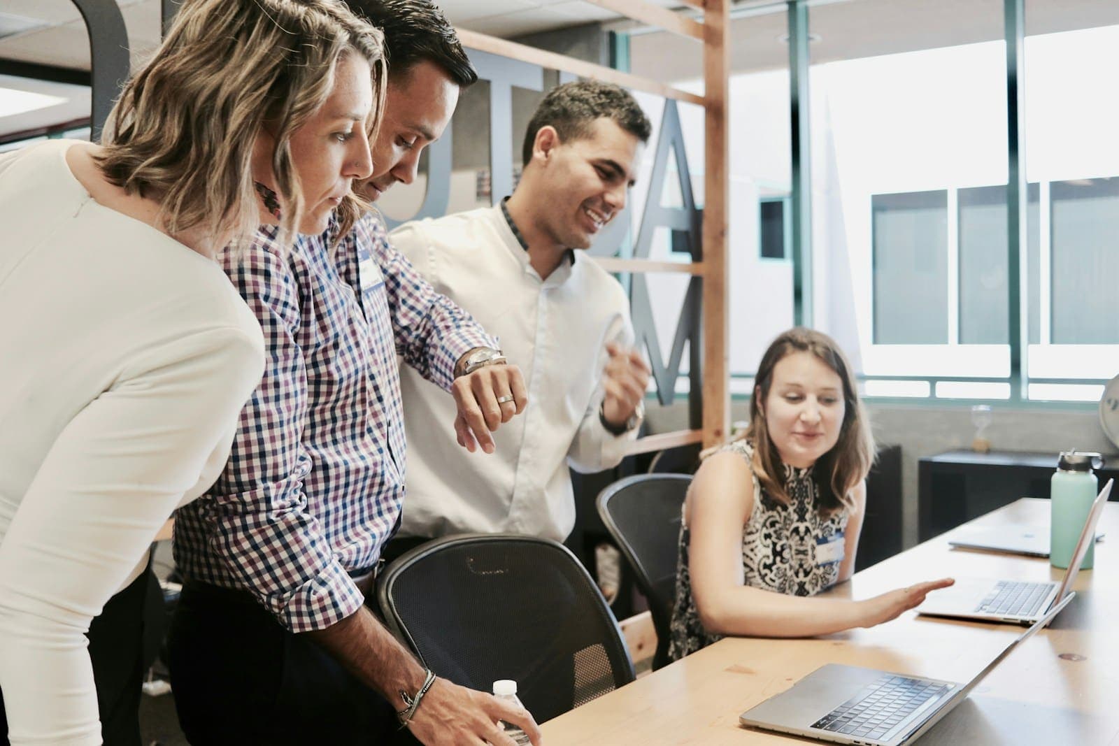 Colleagues reviewing work together at a desk in a bright office