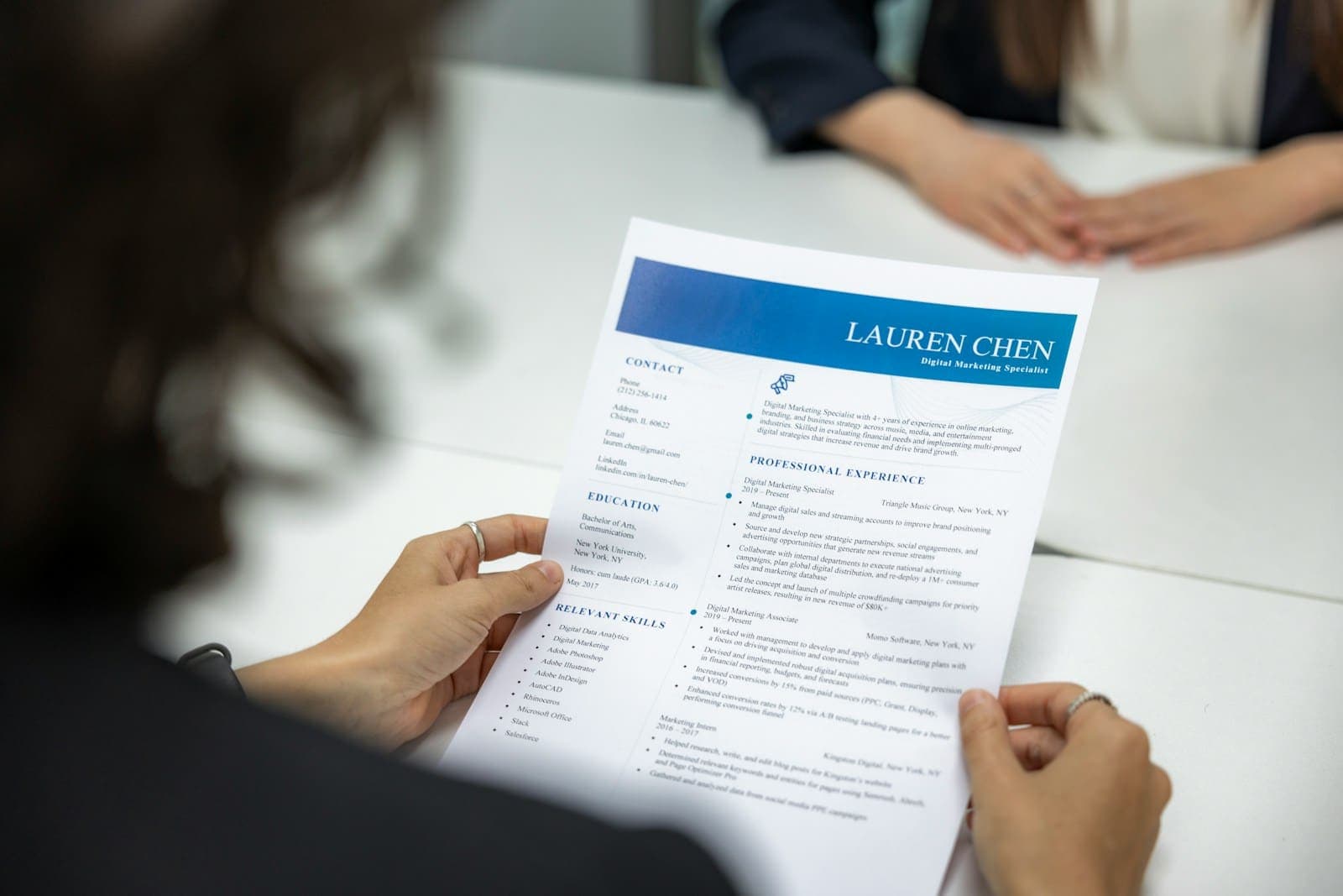 A recruiter reading a printed resume during an interview